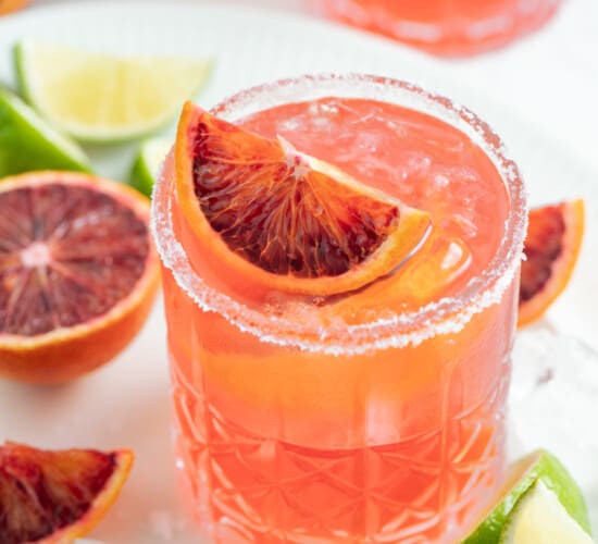 an ruby red colored margarita with blood orange garnish