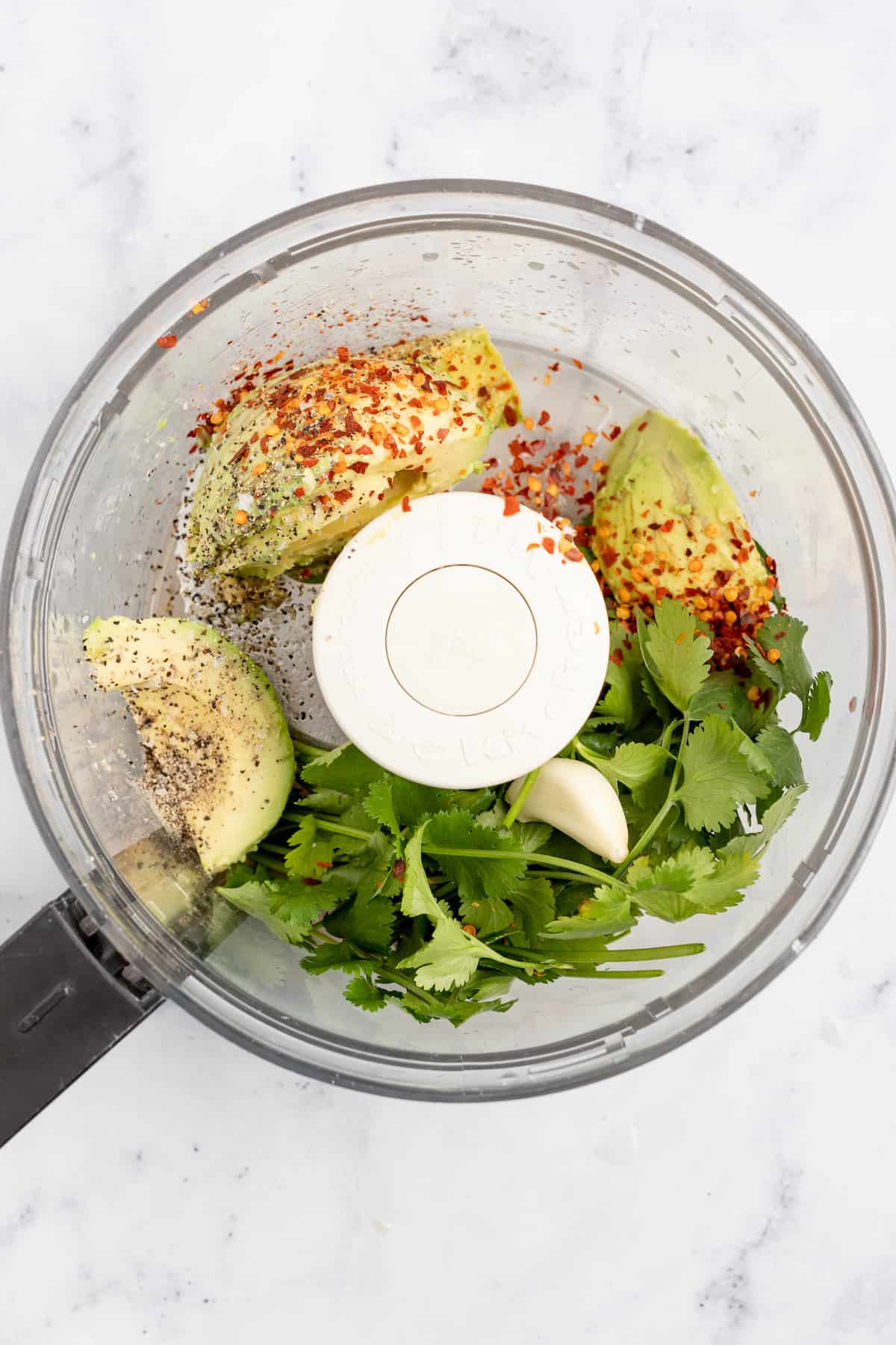 Adding the avocado crema ingredients to the blender.