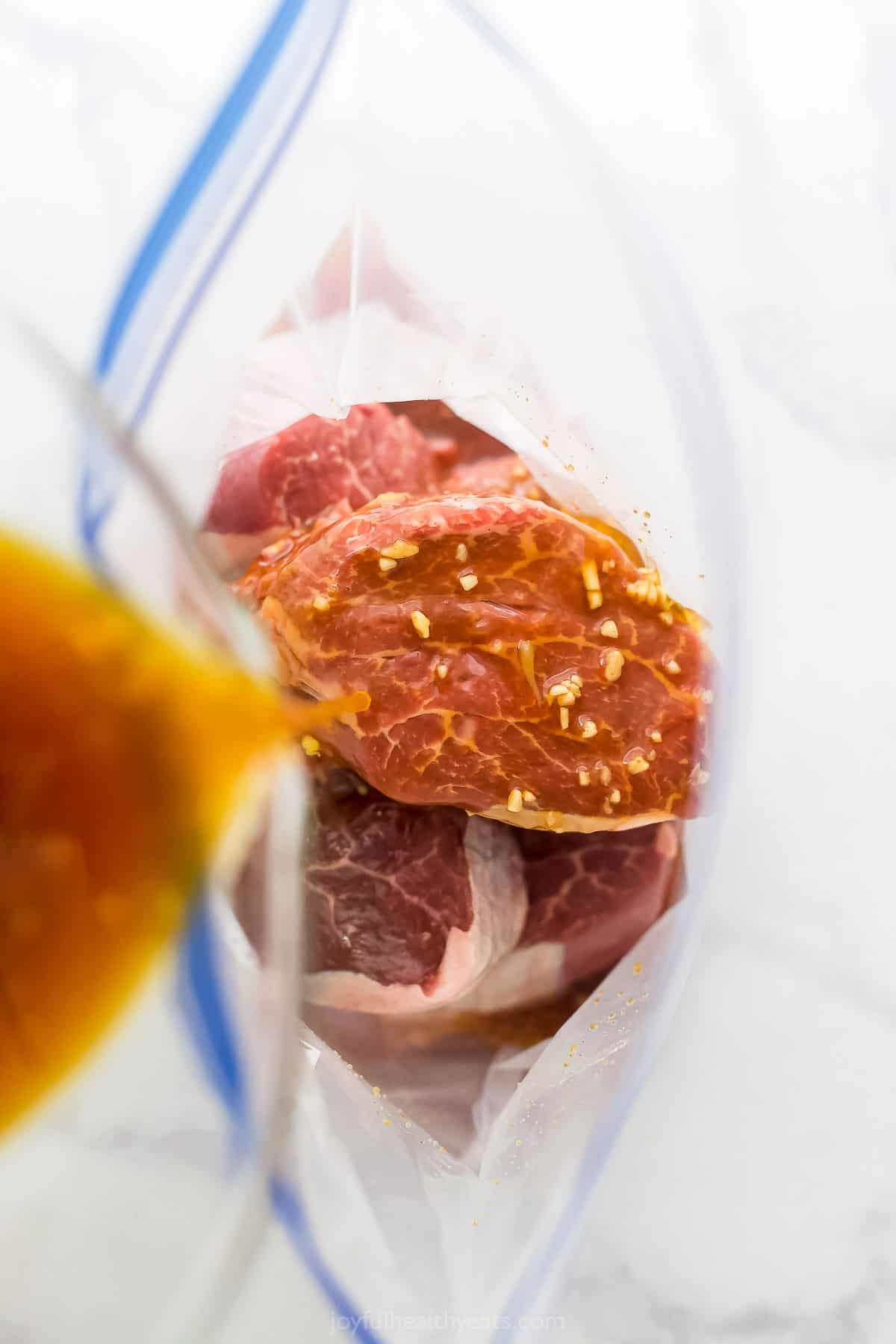 Pouring the marinade into the bag with the filet mignon.