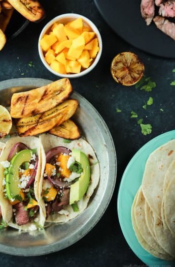 These Grilled Steak Street Tacos are filled with tender Filet Mignon, fresh mango, creamy avocado, and charred onions. The perfect 20 minute steak dinner that tastes like a flavor bomb went off in your mouth! | joyfulhealthyeats.com #glutenfree