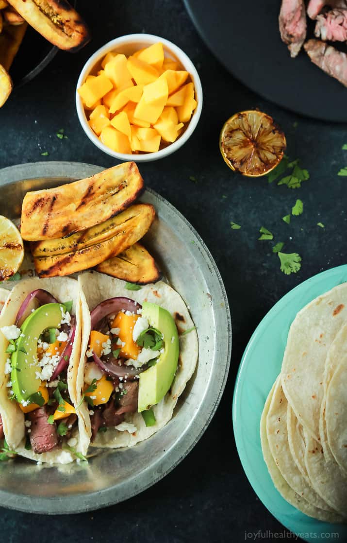 These Grilled Steak Street Tacos are filled with tender Filet Mignon, fresh mango, creamy avocado, and charred onions. The perfect 20 minute steak dinner that tastes like a flavor bomb went off in your mouth! | joyfulhealthyeats.com #glutenfree