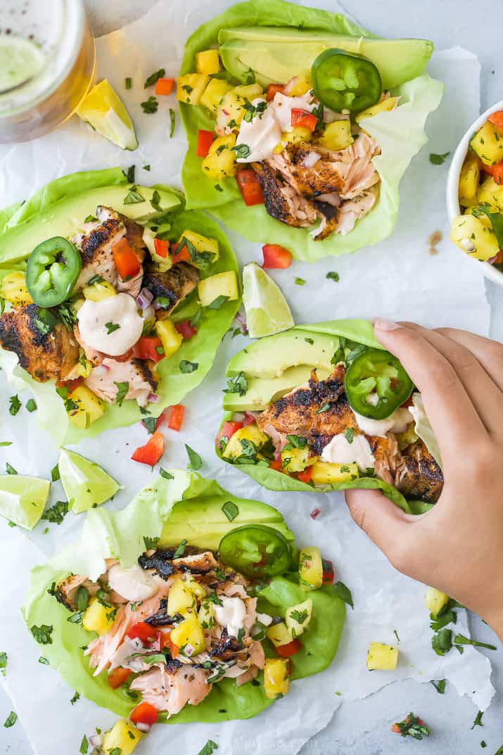 hand grabbing a blackened salmon taco with pineapple salsa