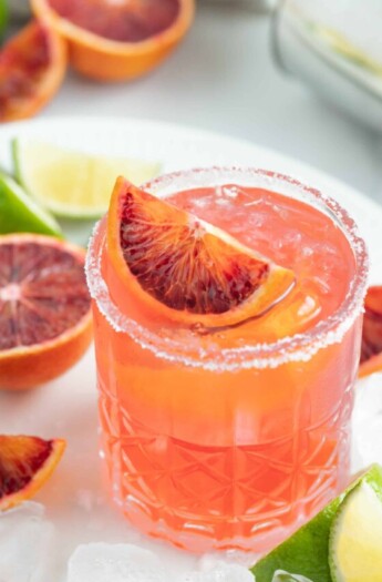 an ruby red colored margarita with blood orange garnish