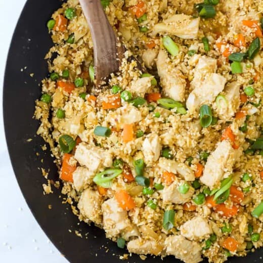 closeup of chicken fried rice with cauliflower in a wok