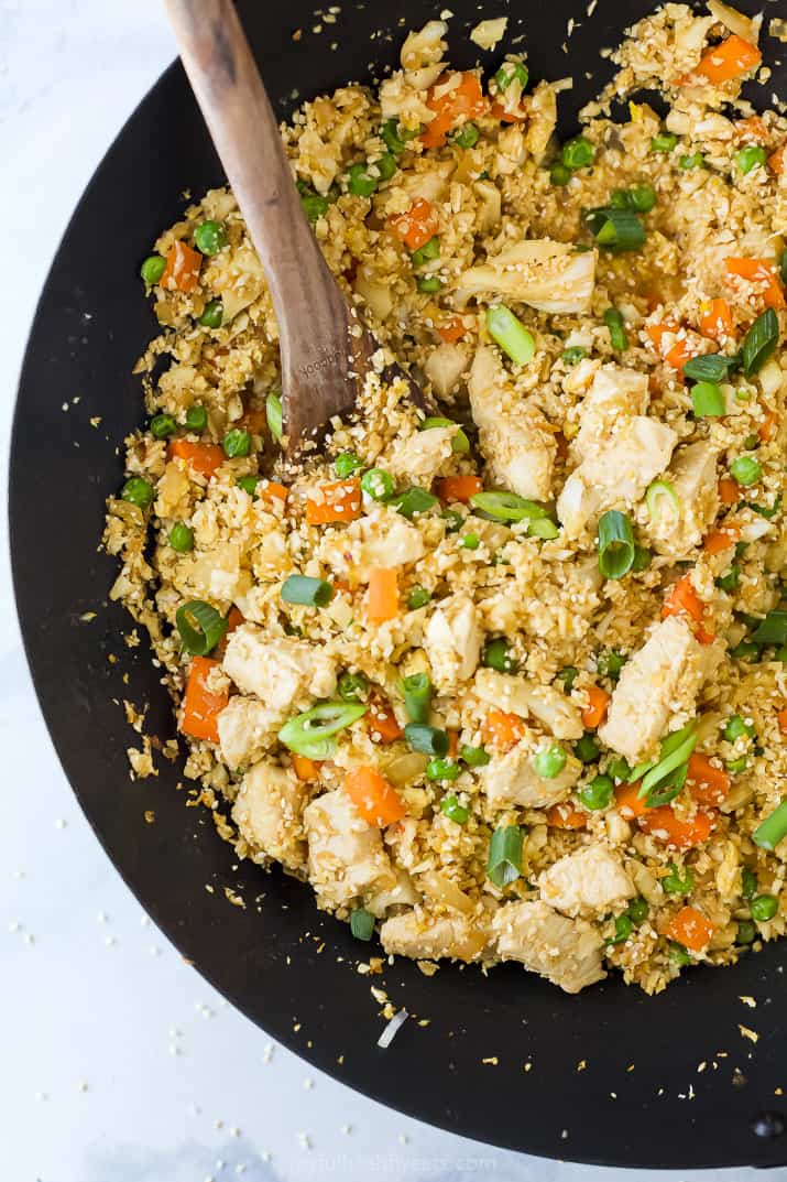 closeup of chicken fried rice with cauliflower in a wok