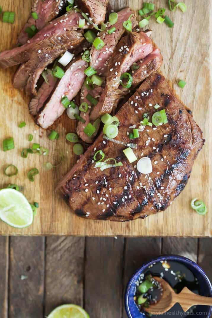 Asian Grilled Flank Steak with scallions on a cutting board