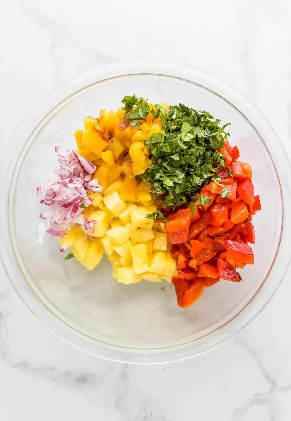 Adding the relish ingredients to a bowl.