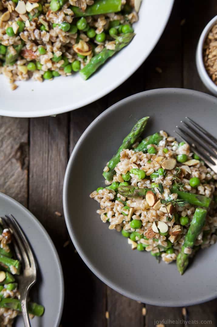 Top view of bowls of Springtime Farro Salad with sweet peas, asparagus, fresh herbs and goat cheese