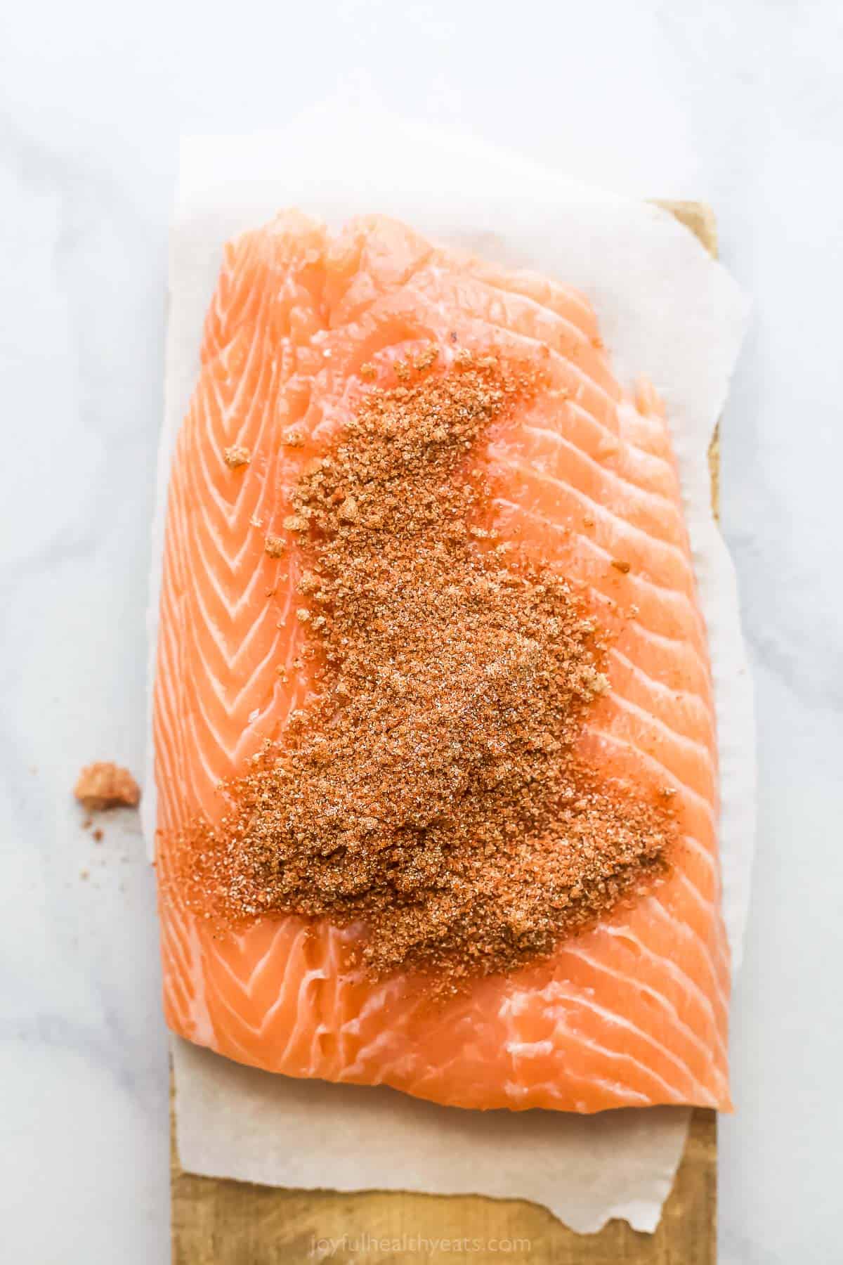 Sprinkling the spice mix on the salmon. 