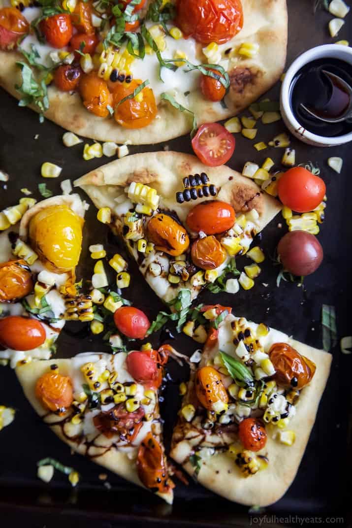 Top view of Charred Corn Caprese Flatbread with Balsamic Reduction cut into quarters