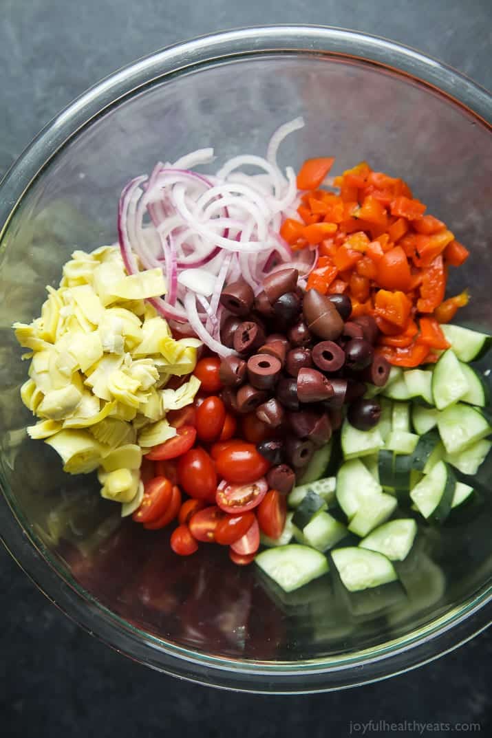 Top view of ingredients for Greek Pasta Salad Recipe in a mixing bowl