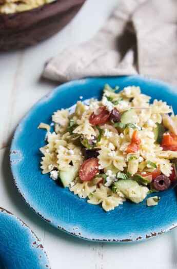 Simple Greek Pasta Salad with cherry tomatoes, artichokes, olives, red onion, cucumber, feta and a homemade dressing! The perfect summer side dish for your next party - I guarantee it will be the first dish to go! | joyfulhealthyeats.com