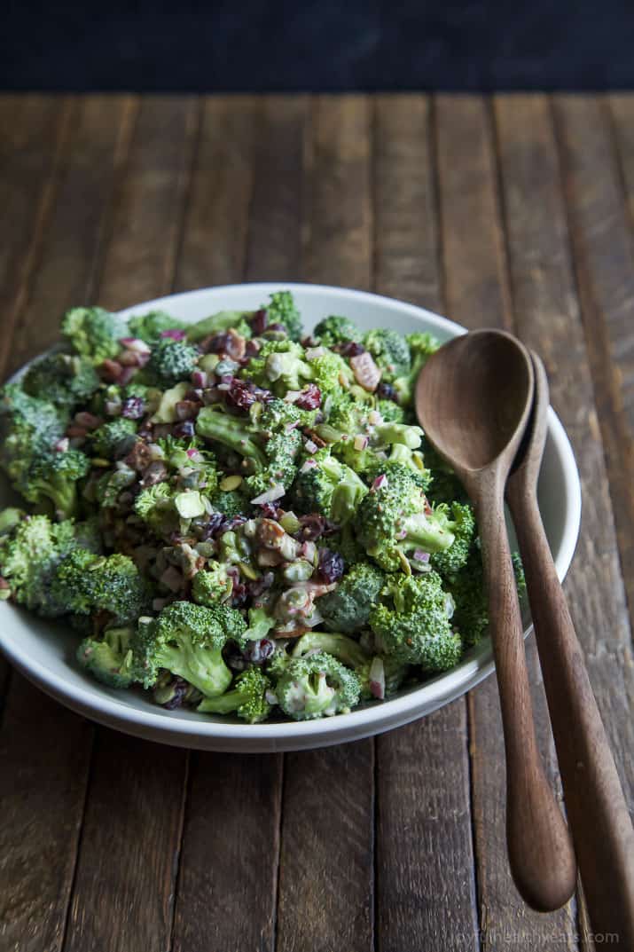 Lightened up Broccoli Salad filled with fresh broccoli, cranberries, red onion, pepitas, BACON, and creamy dressing made with greek yogurt! This salad will be a hit and you'll love the short cut I take! | joyfulhealthyeats.com #glutenfree
