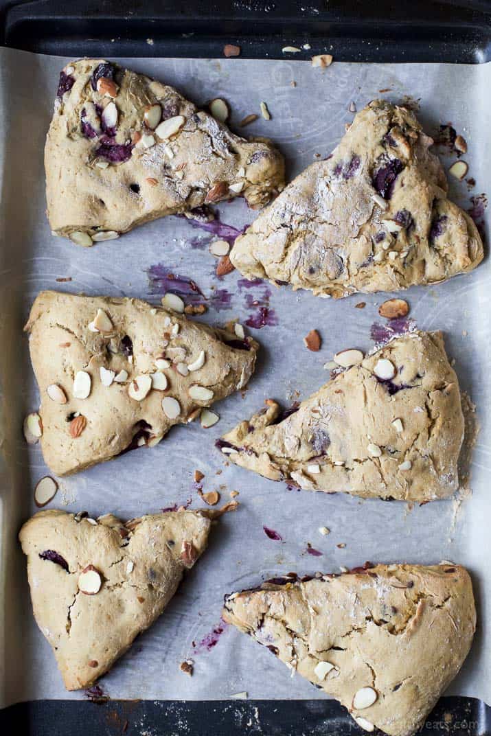 Top view of almond cherry scones on a parchment-lined baking sheet