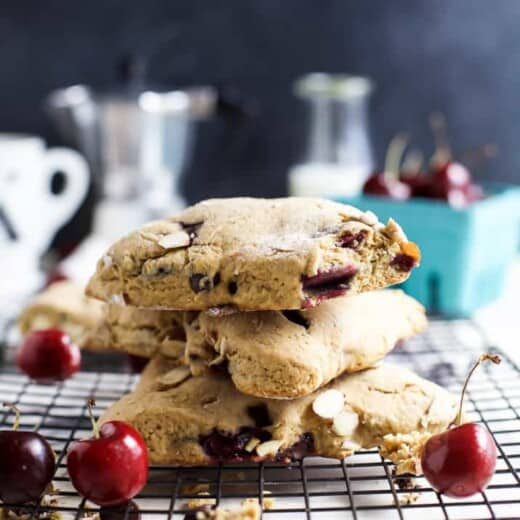 A stack of homemade almond cherry scones on a wire rack for cooling.