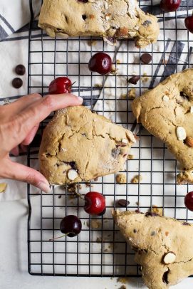 Bitten-into buttery scone with cherries and almonds.