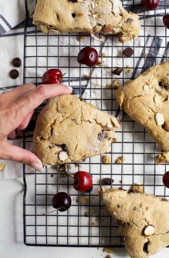 Bitten-into buttery scone with cherries and almonds.