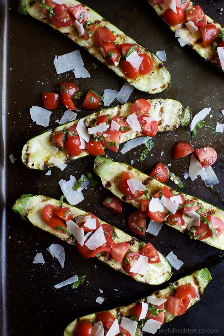 Top view of Grilled Zucchini topped with fresh Tomato Basil Bruschetta and Parmesan