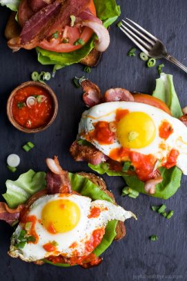 An Open Faced Sandwich with Bacon, Lettuce, Tomatoes, Eggs and Spicy Harissa