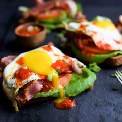 A Close-Up Shot of an Open Faced BLT Sandwich on a Black Serving Platter