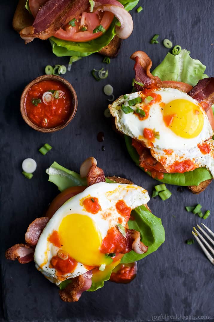 Two Open Faced BLT Egg Sandwiches with Harissa on the Side and Drizzled on Top