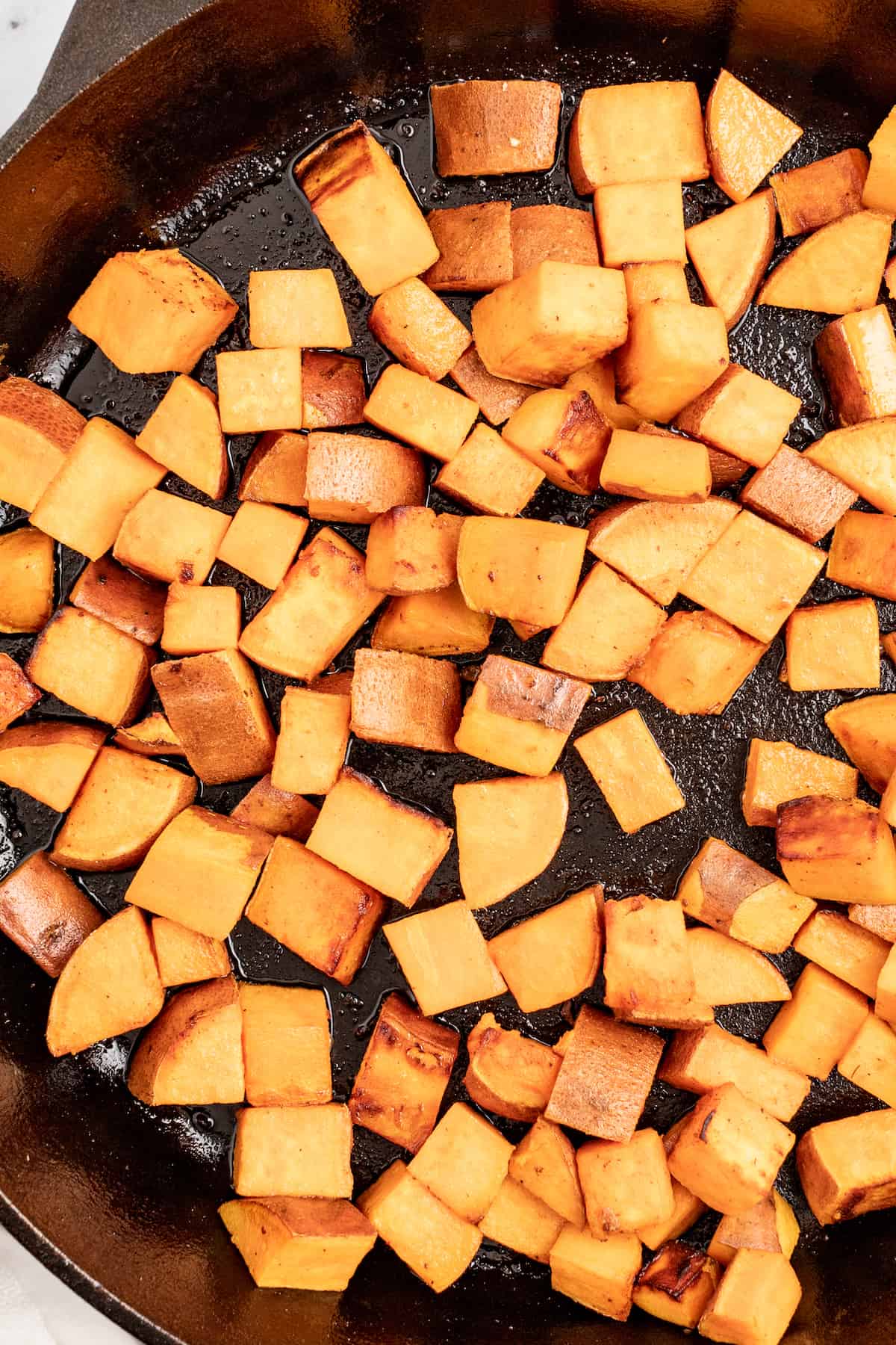 Browned sweet potatoes in the skillet. 