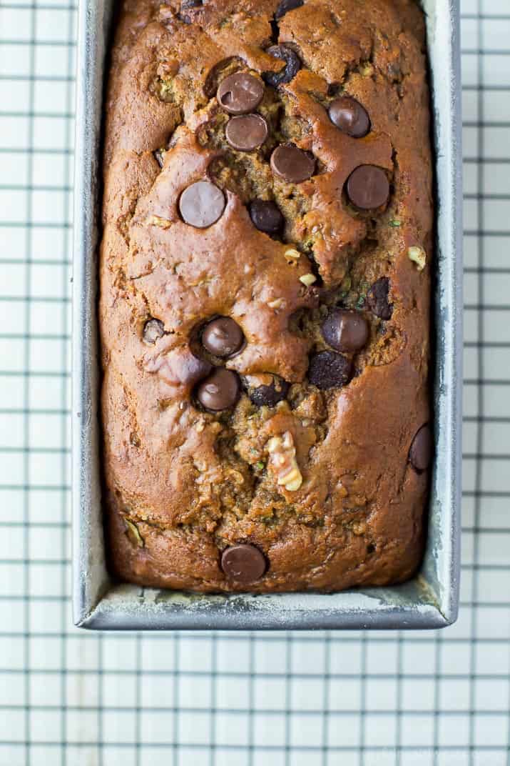 Top view of a loaf of Chocolate Chip Zucchini Bread in a pan on a cooling rack