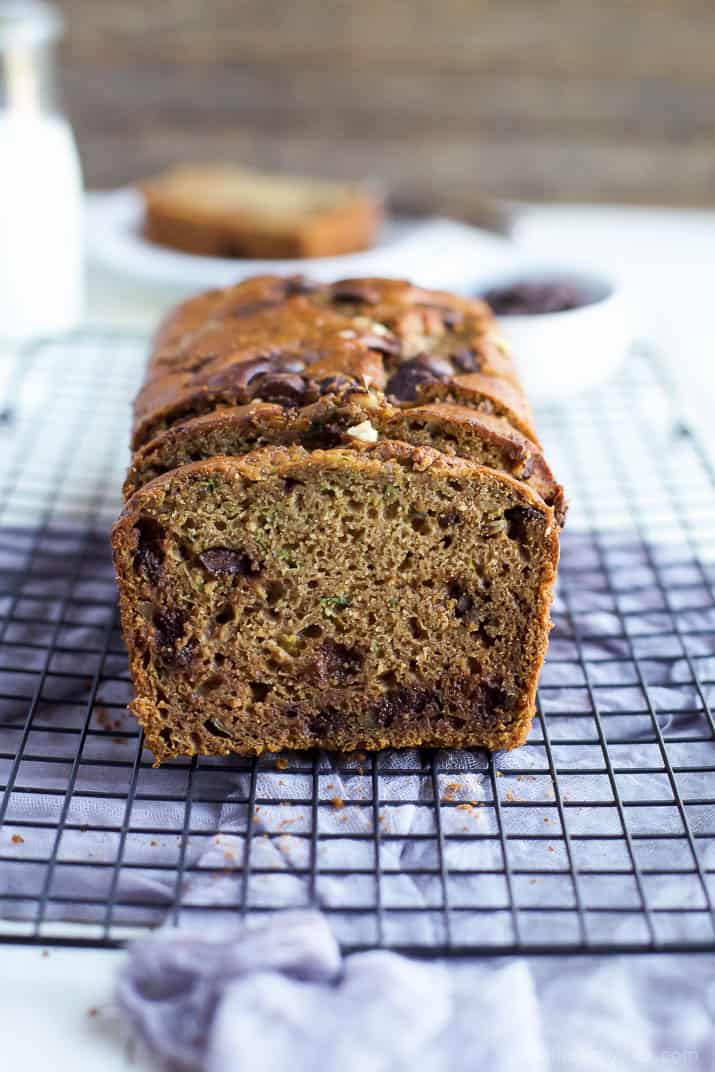 A partially slice loaf of Chocolate Chip Zucchini Bread on a cooling rack