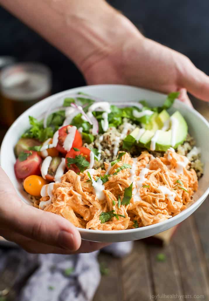 Buffalo Chicken Quinoa Bowls topped with avocado, tomato, shredded buffalo chicken, drizzled with ranch and served on a bed of quinoa. Football food just got a healthy facelift! | joyfulhealthyeats.com #glutenfree