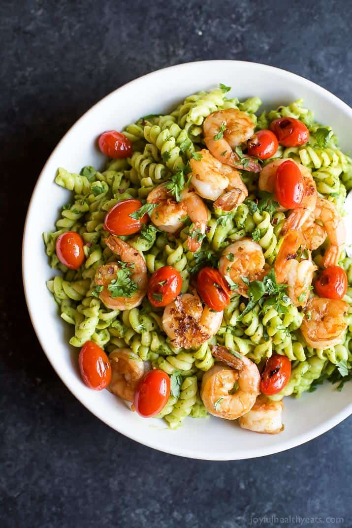 Top view of Chimichurri Avocado Pasta with Pan Seared Shrimp and grape tomatoes in a bowl