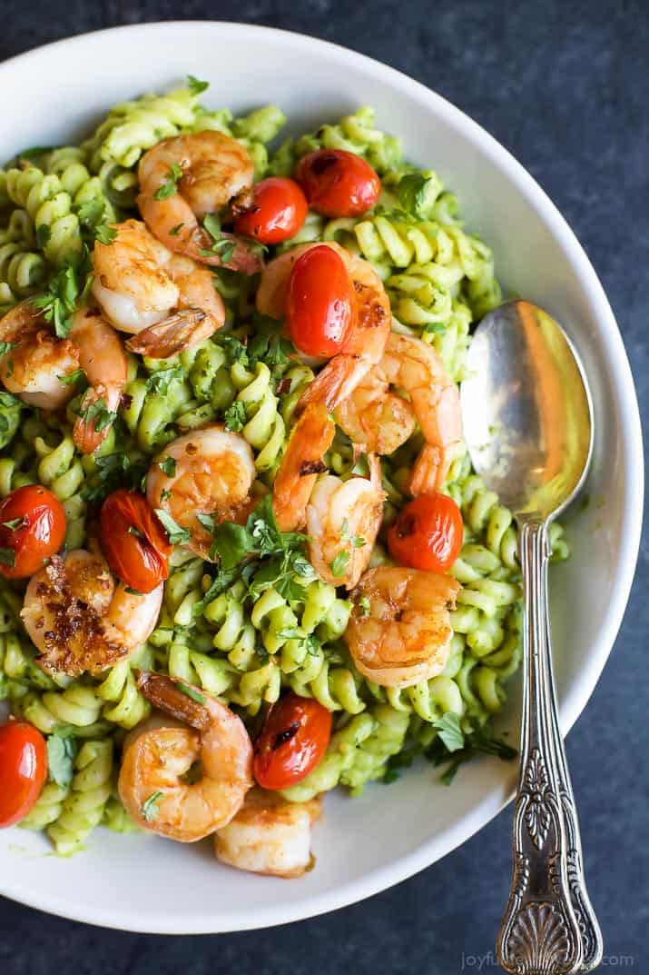 Top view of a bowl of Chimichurri Avocado Pasta with Pan Seared Shrimp and grape tomatoes