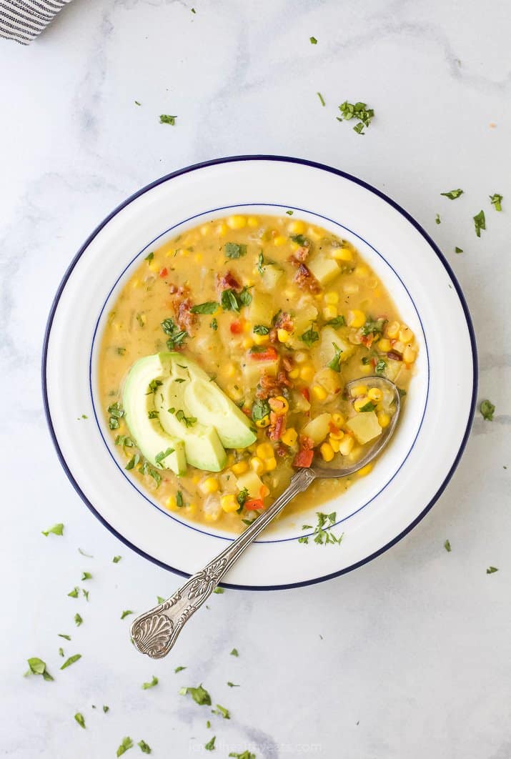 overhead crock pot potato corn chowder in a bowl with a spoon