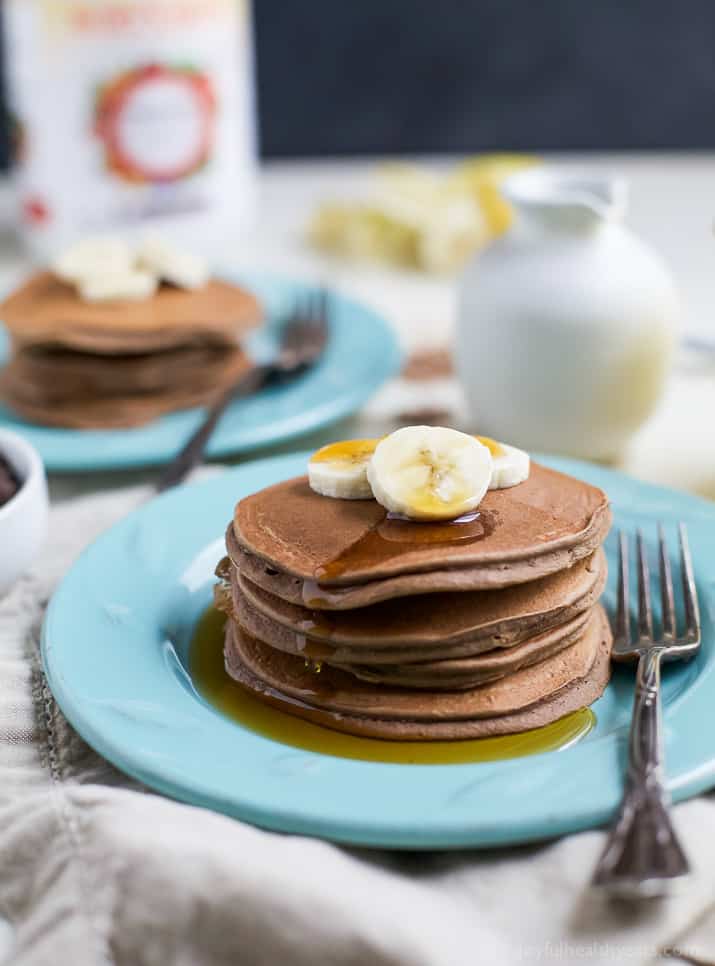 a plate of chocolate panckes with banana slices and maple syrup