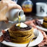 Pumpkin pancakes topped with two pats of butter and a drizzle of pure maple syrup