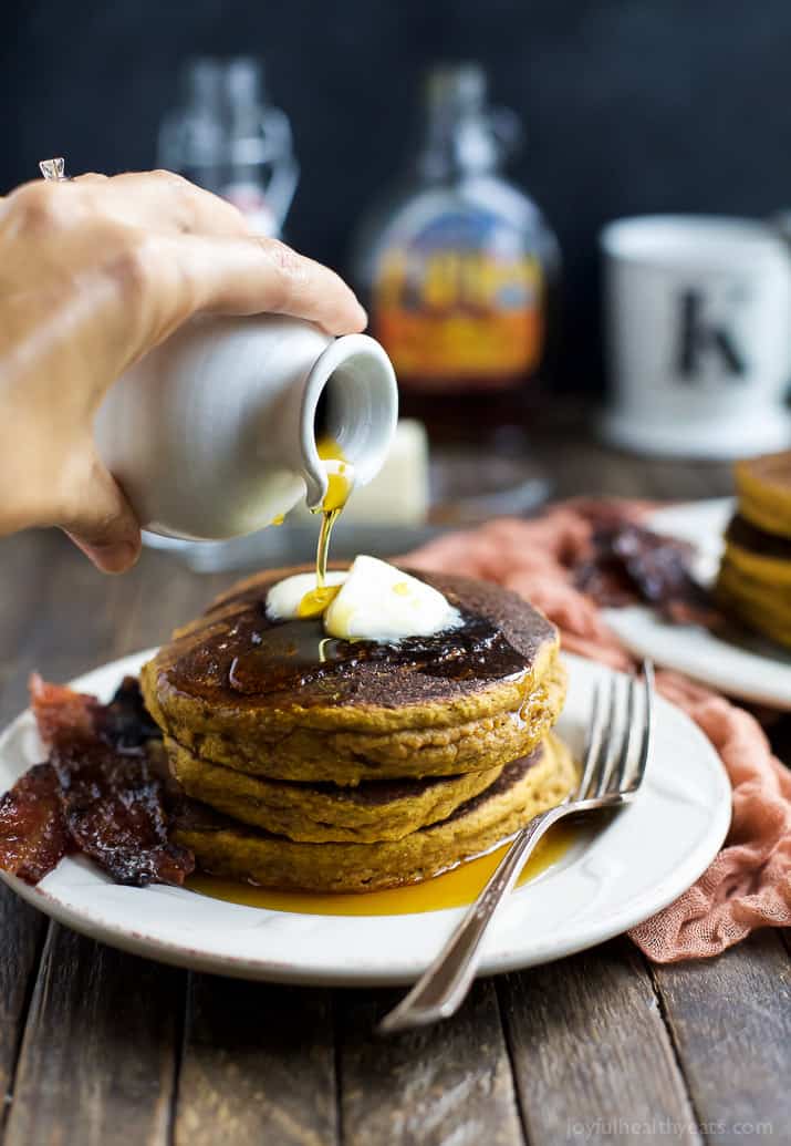 Pumpkin pancakes topped with two pats of butter and a drizzle of pure maple syrup