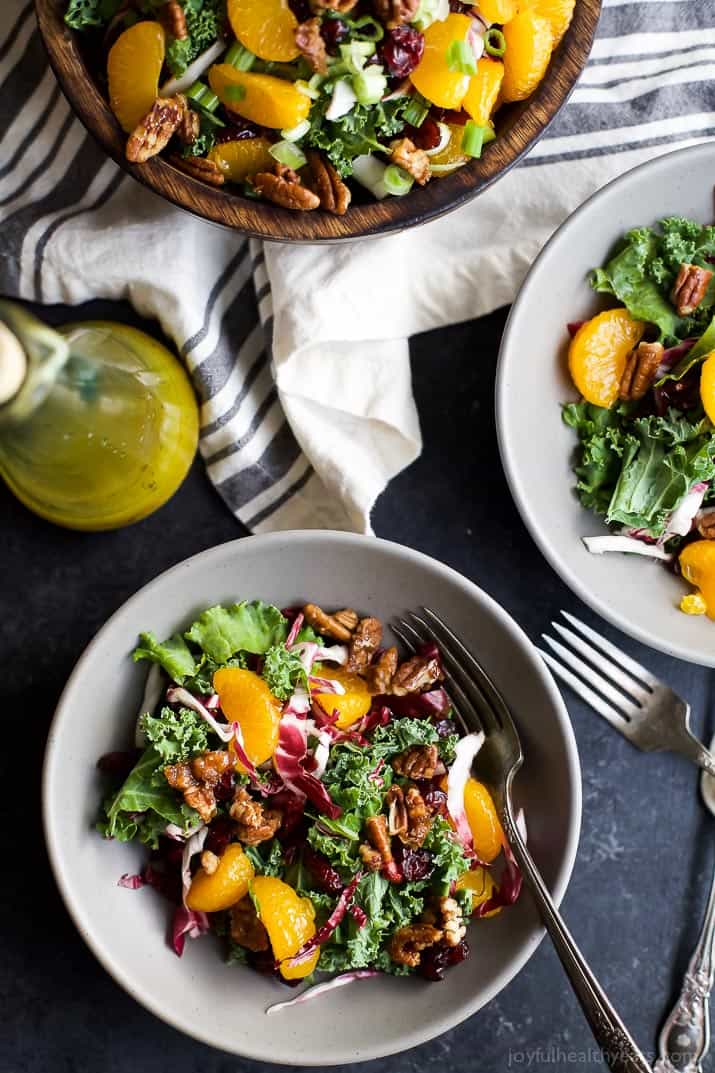 A simple KALE SALAD filled with mandarin oranges, tart cranberries and candied pecans for the perfect bite! I guarantee this salad will win over any kale hater and become a staple at your house! | joyfulhealthyeats.com #glutenfree