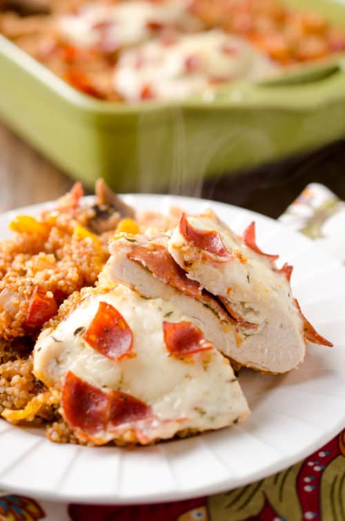 Pizza Stuffed Chicken Quinoa Bake is a hearty but healthy casserole filled with fluffy quinoa and your favorite pizza toppings along with garlic herb cheese and pepperoni stuffed chicken breasts for a dinner recipe the whole family will love!