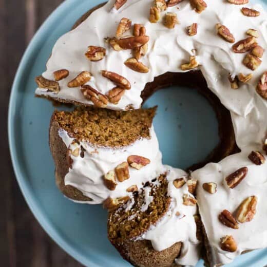 An overhead shot of a frosted pumpkin bundt cake with two slices cut out