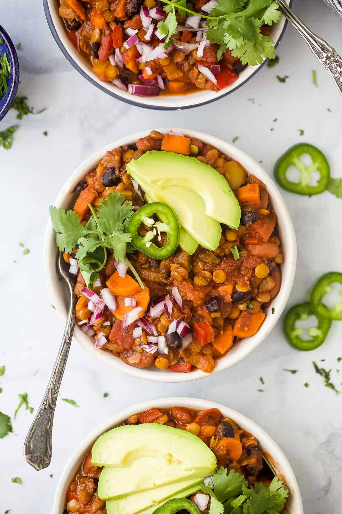 Vegetarian lentil chili in a bowl with toppings.