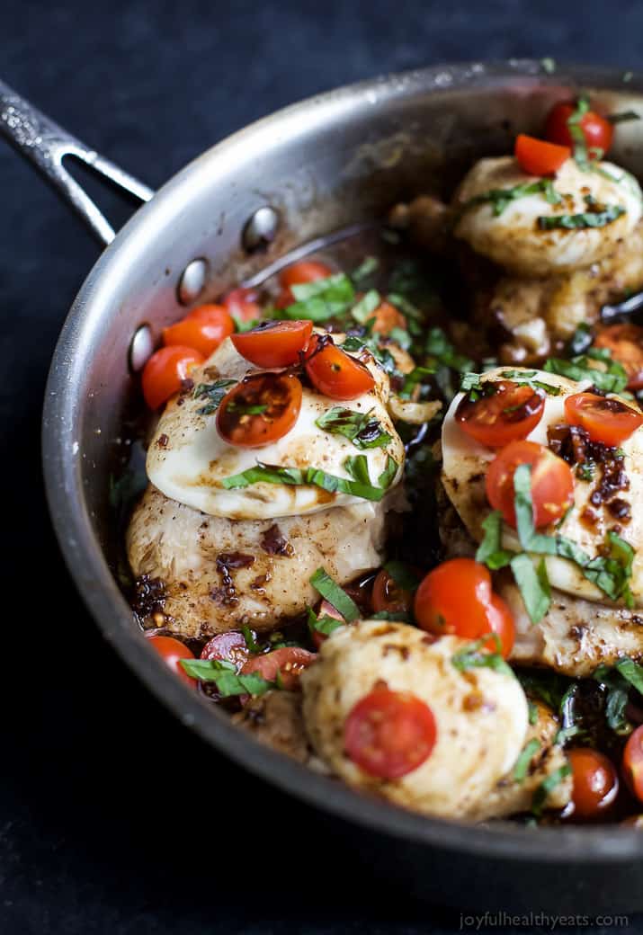 Close-up Image of Balsamic Glazed Caprese Chicken in a pan which is chicken with cheese, tomatoes, and fresh basil 