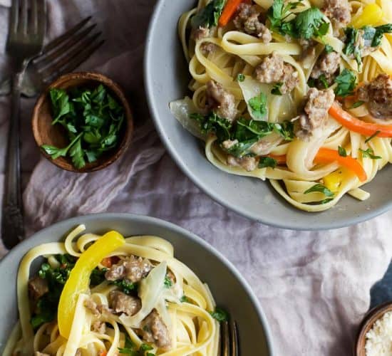 A quick and easy Creamy Kale Pepper & Sausage Pasta that's finished in just under 30 minutes! The perfect cheesy bowl of noodles you'll want to cozy up with at night! | joyfulhealthyeats.com