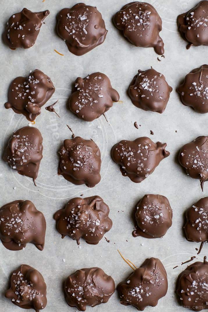 Top view of Espresso Cashew Clusters with sea salt on a parchment-lined baking sheet