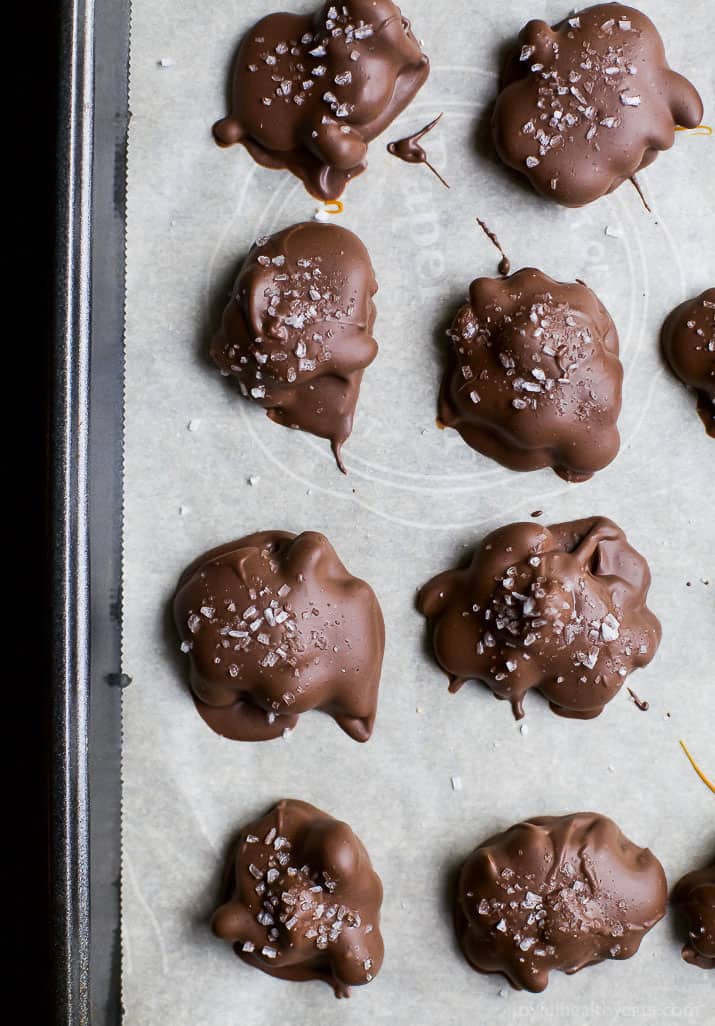 Top view of Espresso Cashew Clusters with sea salt on a parchment-lined baking sheet