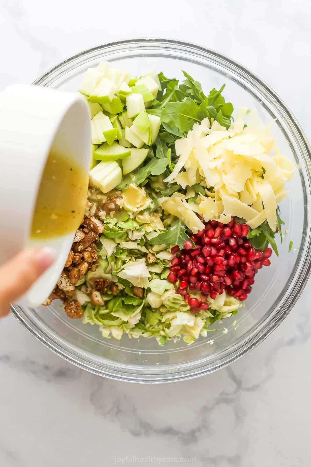 Versez la vinaigrette dans un bol à ingrédients pour la salade de choux de Bruxelles.