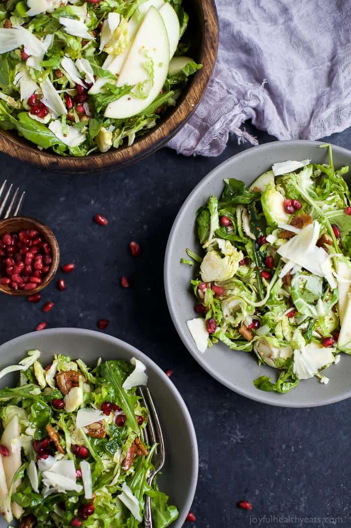 Shaved Brussel Sprout Salad filled with apples, pomegranate, candied pecans, and white cheddar cheese then tossed with a light Lemon Vinaigrette. This Brussel Sprout Salad is the perfect side dish for the holidays! | joyfulhealthyeats.com #glutenfree