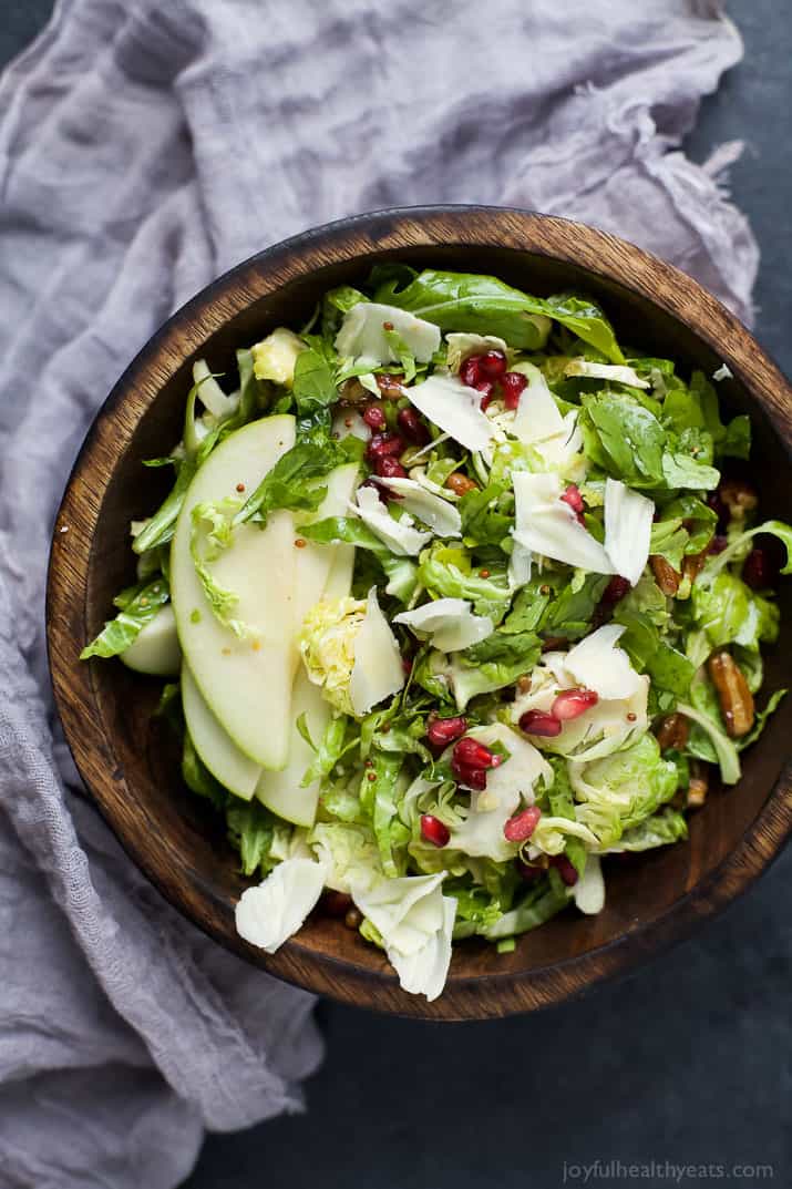 Shaved Brussel Sprout Salad filled with apples, pomegranate, candied pecans, and white cheddar cheese then tossed with a light Lemon Vinaigrette. This Brussel Sprout Salad is the perfect side dish for the holidays! | joyfulhealthyeats.com #glutenfree