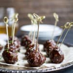 asian crockpot meatballs with skewers in them