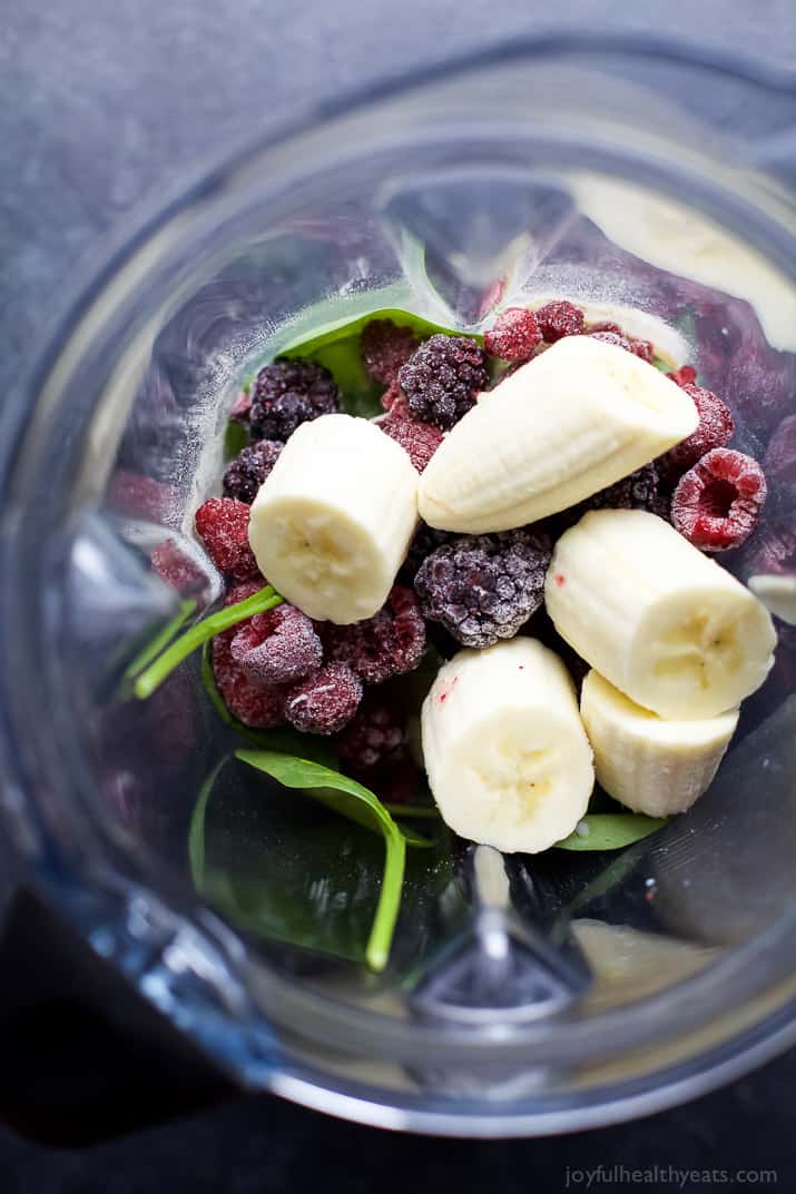 Banana chunks, frozen berries and spinach in a blender jar