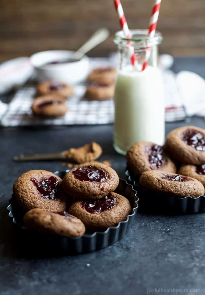 Chocolate Raspberry Thumbprint Cookies in mini tart pans with a glass of milk