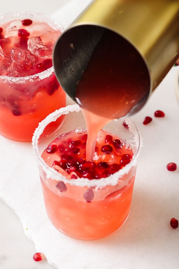 Pouring the cocktail into the serving glass. 